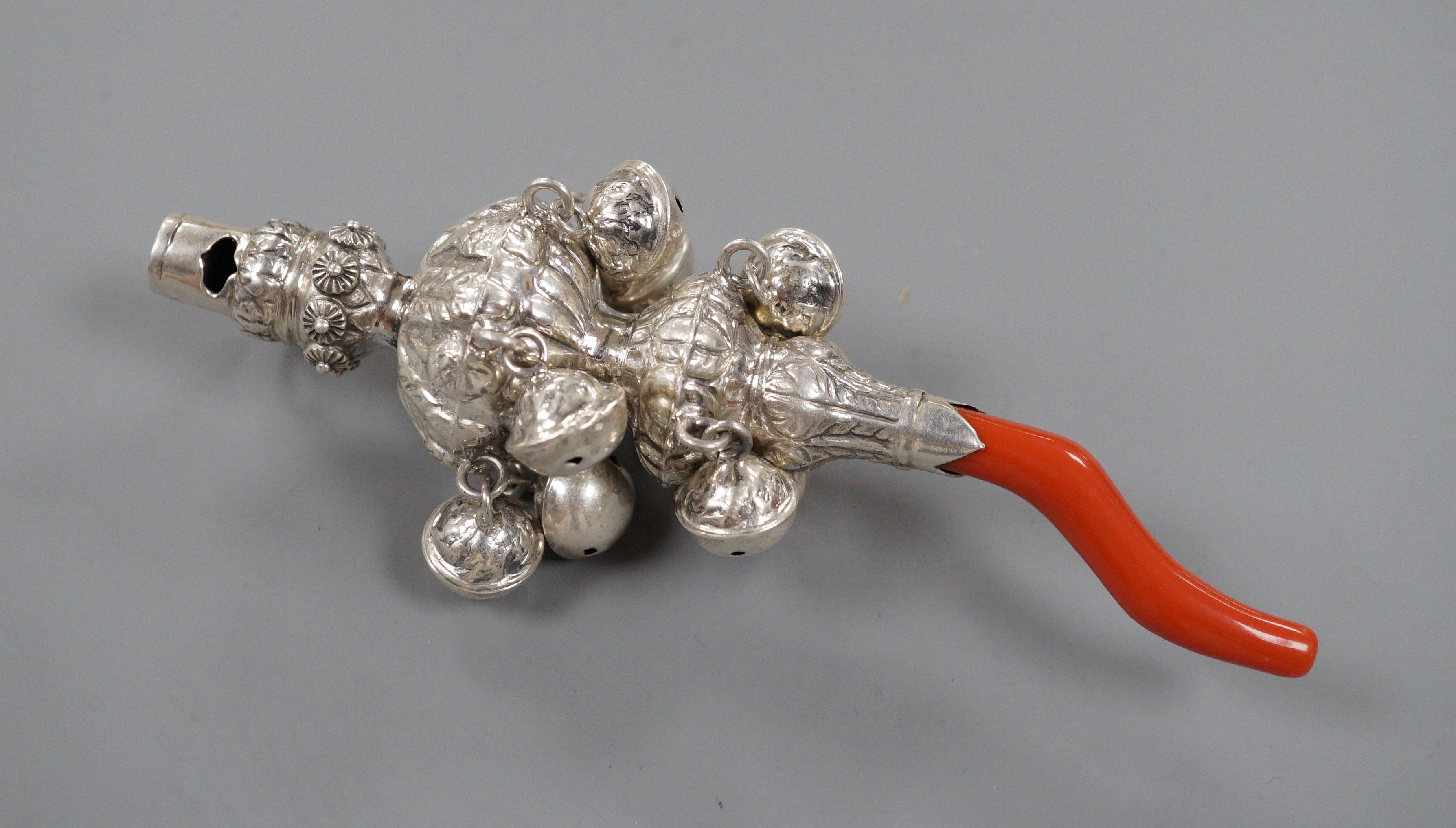 A late 19th/early 20th century white metal and coral set child's rattle, maker's mark only for George Unite, 14cm.